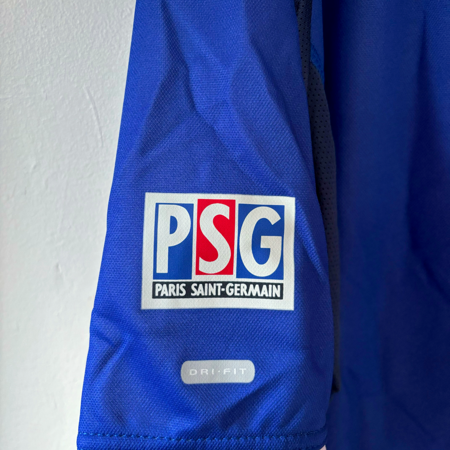 Blue sleeve of vintage retro football shirt featuring PSG logo patch and Nike Dri-FIT label. - BWNT Paris Saint Germain PSG 1999-2000 Home Football Shirt Maillot Nike