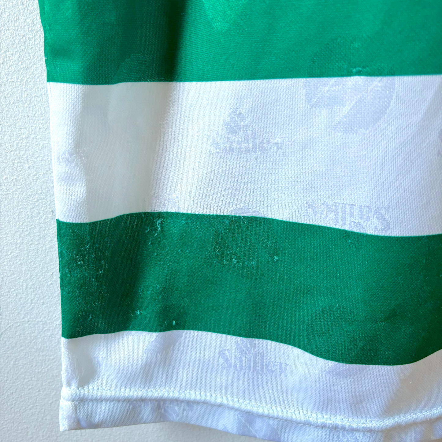 Green and white striped vintage football shirt fabric close-up with embossed Saillev logo detailing. - Sporting CP Club Lisbon 1995-1996 Home Football Camisa Shirt Saillev