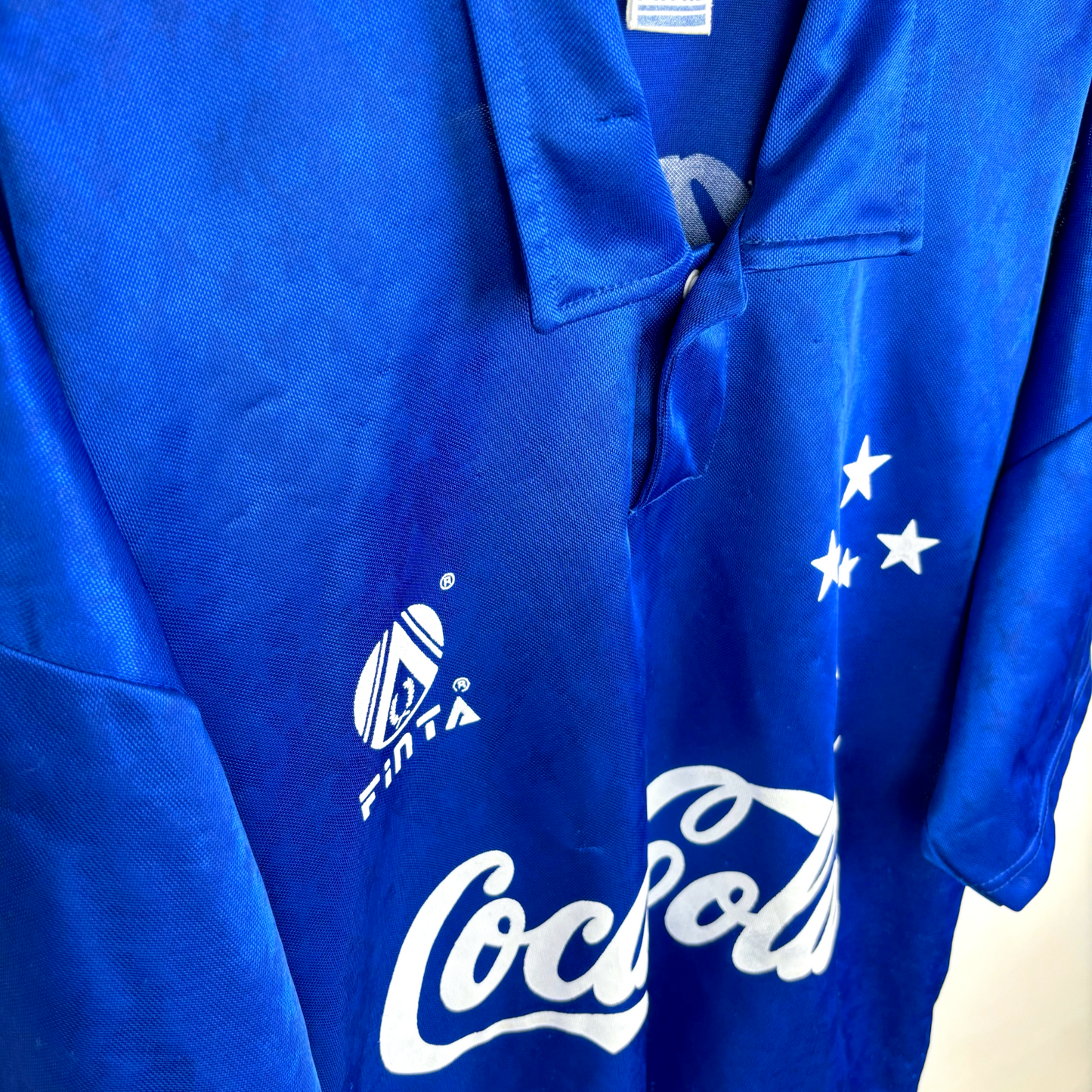 Side close up view of Cruzeiro vintage football shirt from the 1993-1995 seasons with white sponsor and logos, classic collar, short sleeves.