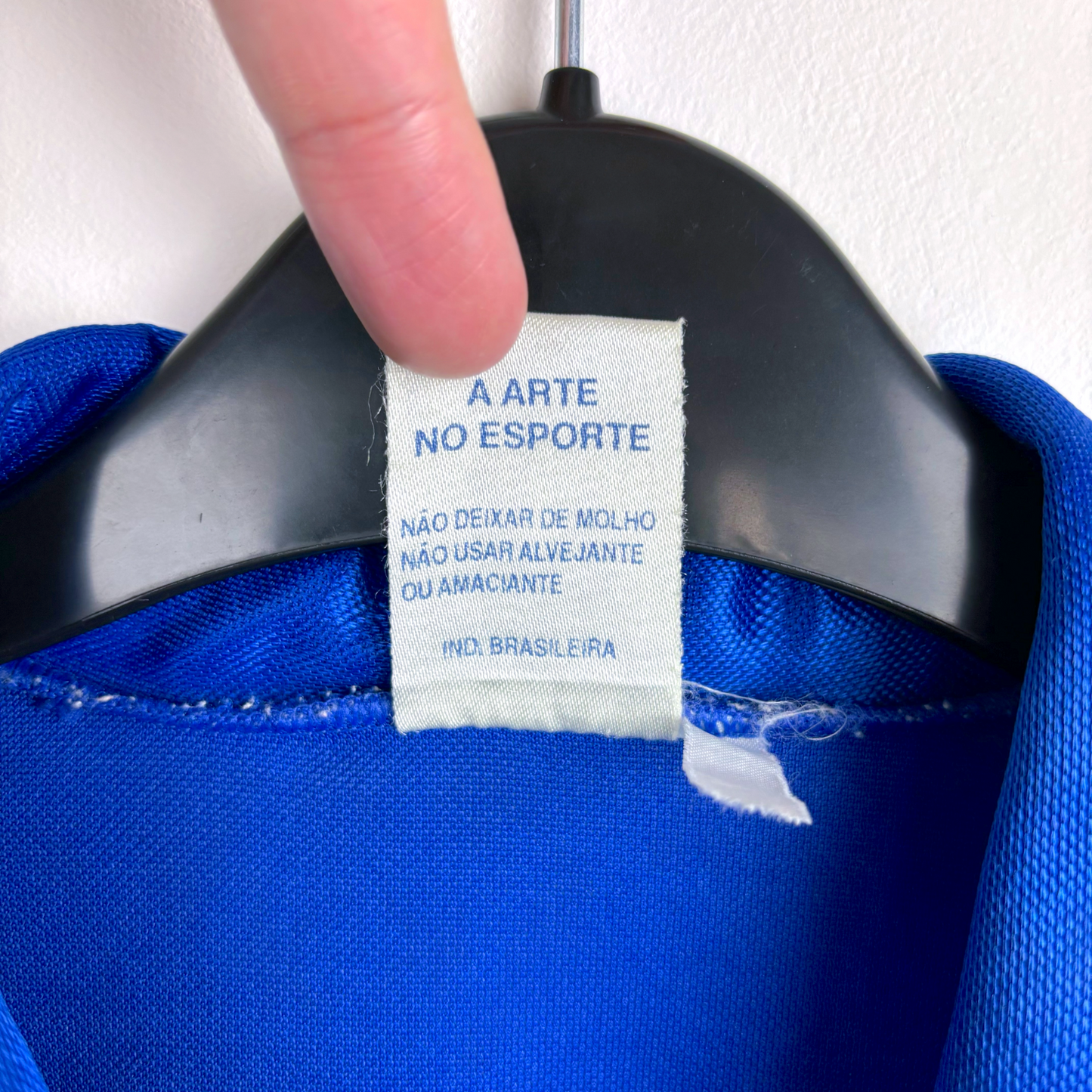 White fabric care tag inside blue retro football shirt with Portuguese text and collar seam visible. - Cruzeiro 1993/1994/1995 Home Football Shirt Camisa Finta