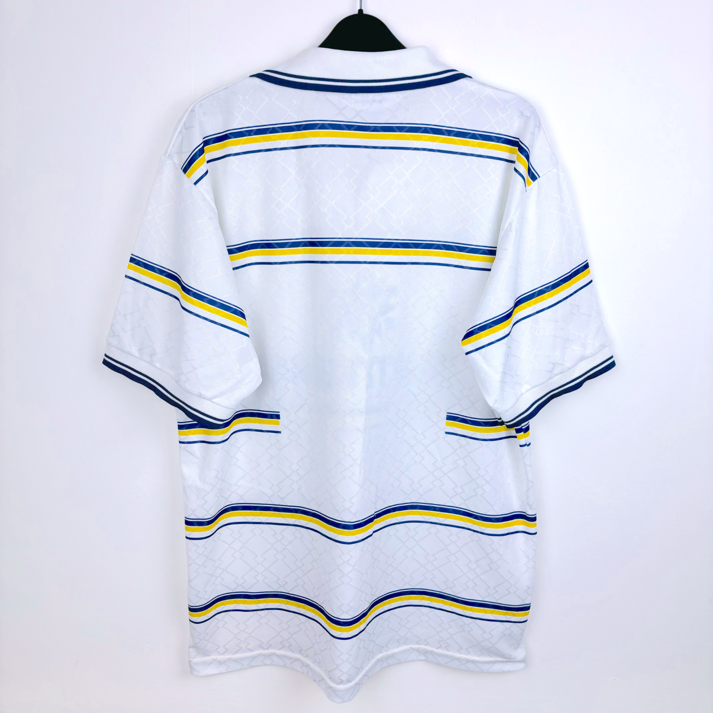 Rear view of retro shirt of Parma AC produced by Lotto. White body featuring blue and yellow hoops.
