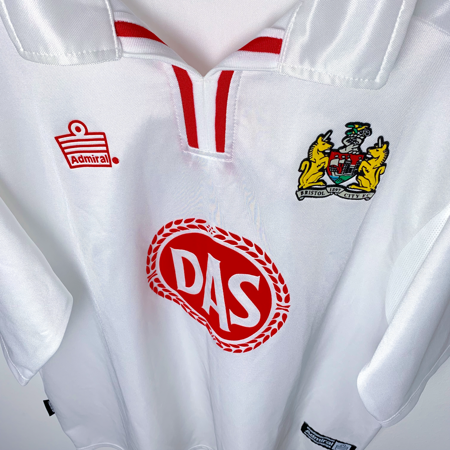 Downward view of old Bristol City away football shirt by Admiral in white. DAS red sponsor and Admiral logo.