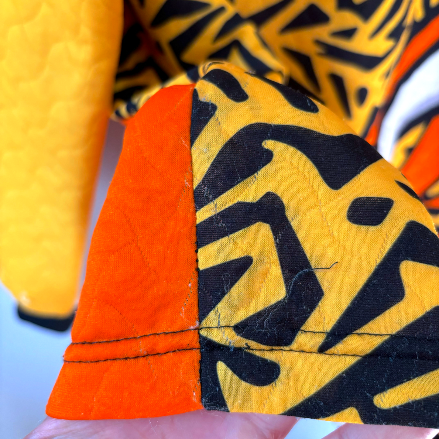 Liverpool FC 1995-1996 vintage football shirt sleeve detail with yellow quilted fabric and black geometric pattern on orange . - Liverpool FC 1995-1996 Goal Keeper Football Shirt Adidas