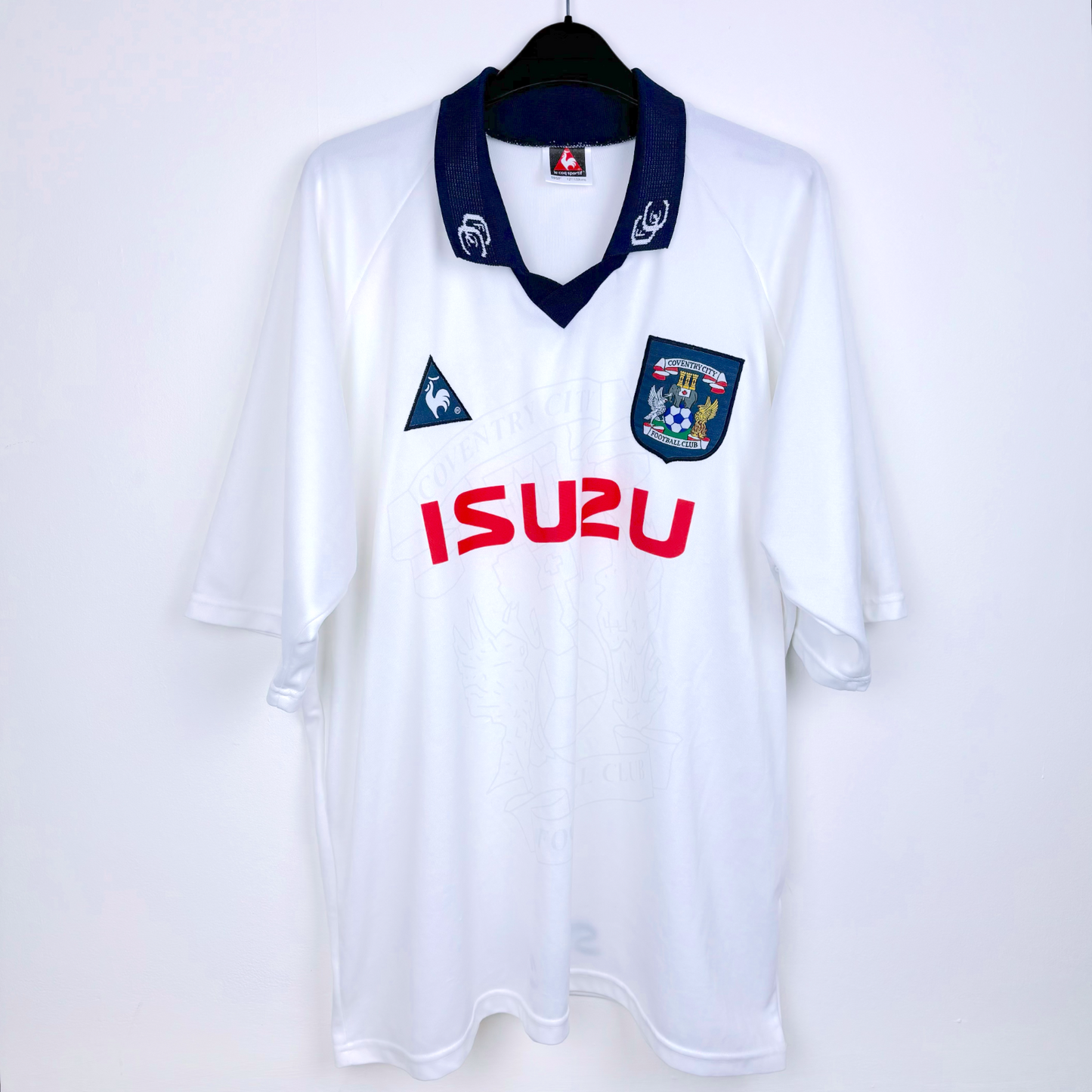 Frront view of white Coventry City vintage football shirt produced by le coq sportif. Embroidered Coventry badge with red Izuzu sponsor.