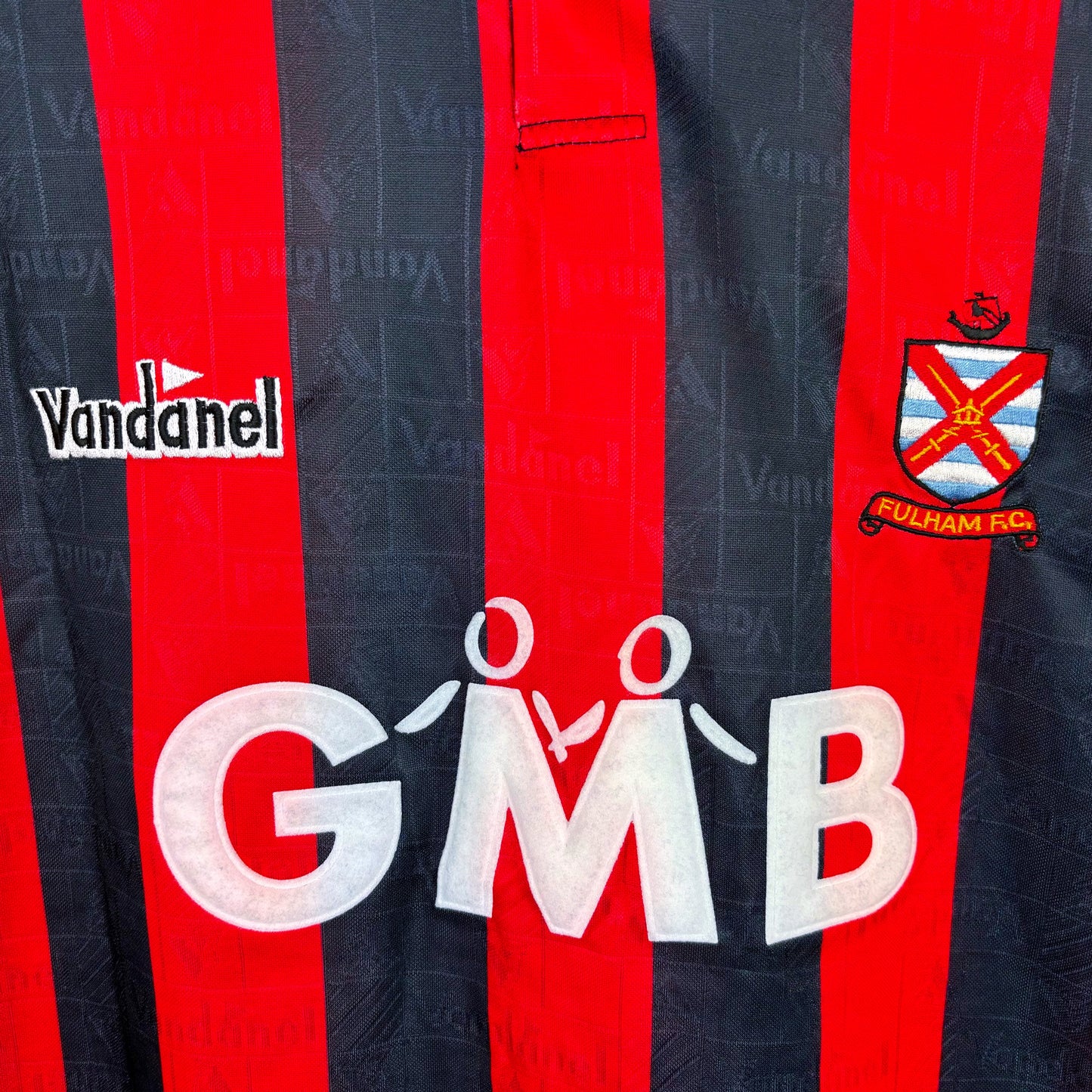 Close-up of Vandanel logo on Fulham FC 1993-1994 away football shirt with GMB sponsor, red and black design, vintage retro soccer jersey