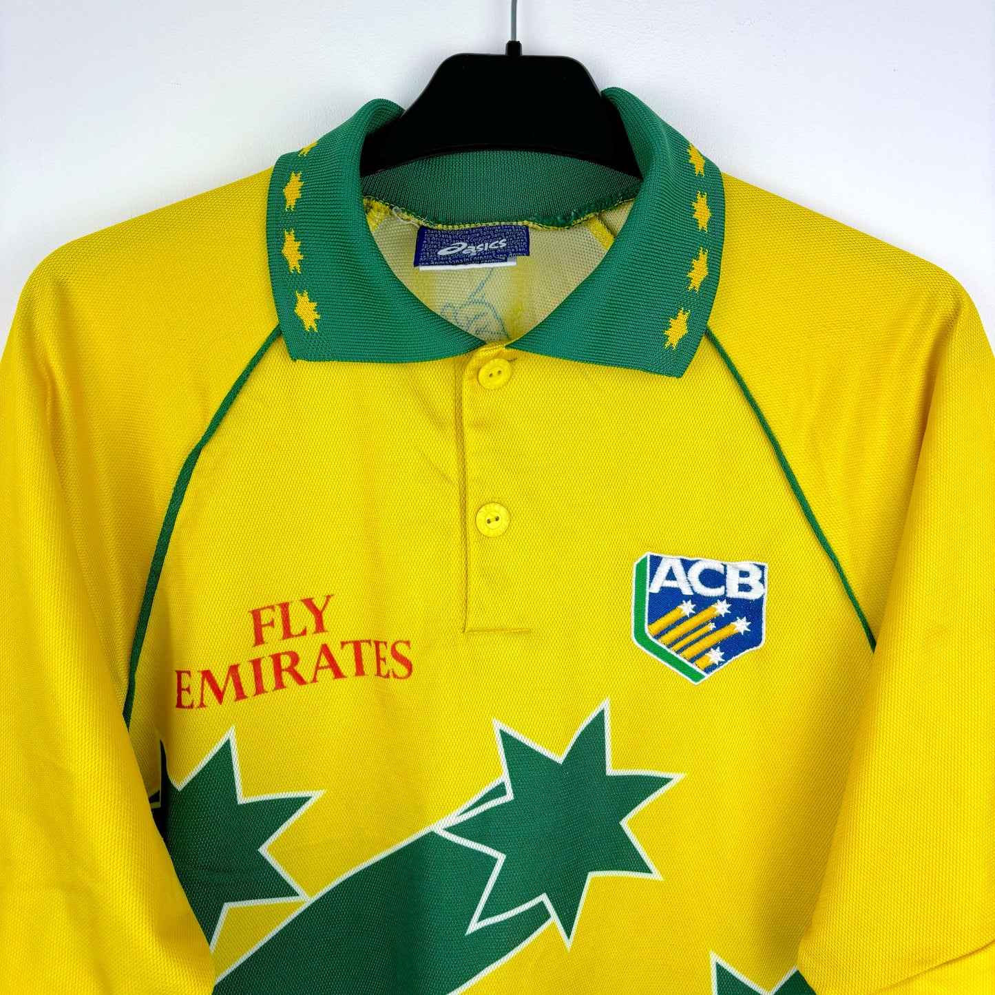 Australia 1999 World Cup cricket shirt by Asics, front close up view highlighting yellow and green star design with embroidered crest and printed Fly Emirates sponsor