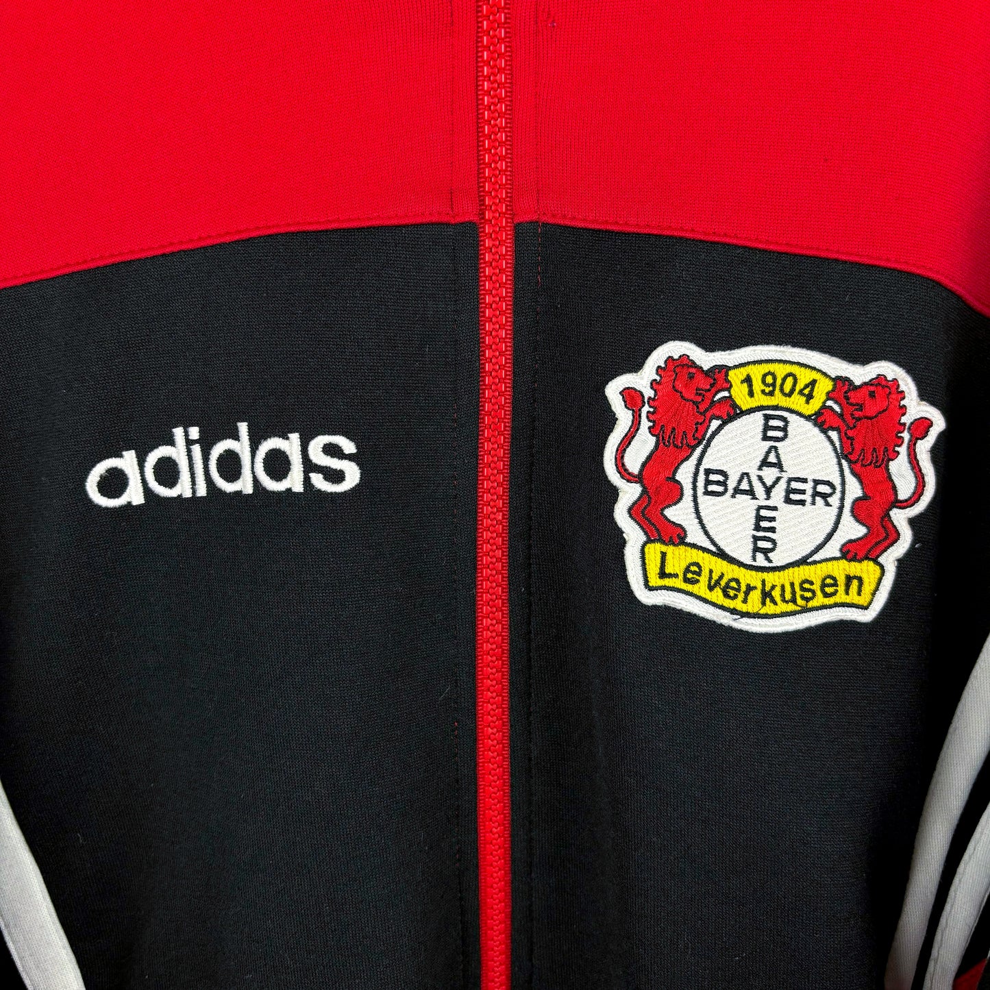Close-up of Adidas logo on Bayer Leverkusen 1995-1997 football training zip-up track jacket, vintage retro sportswear