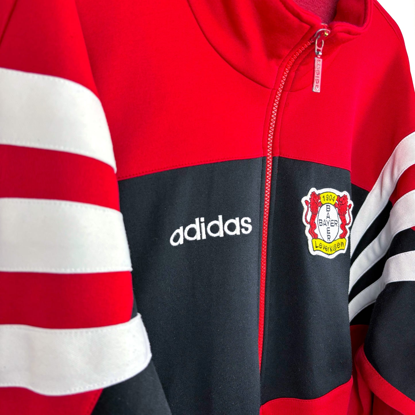 Side view of Bayer Leverkusen 1995-1997 Adidas football training zip-up track jacket, black with red and white accents, retro sportswear