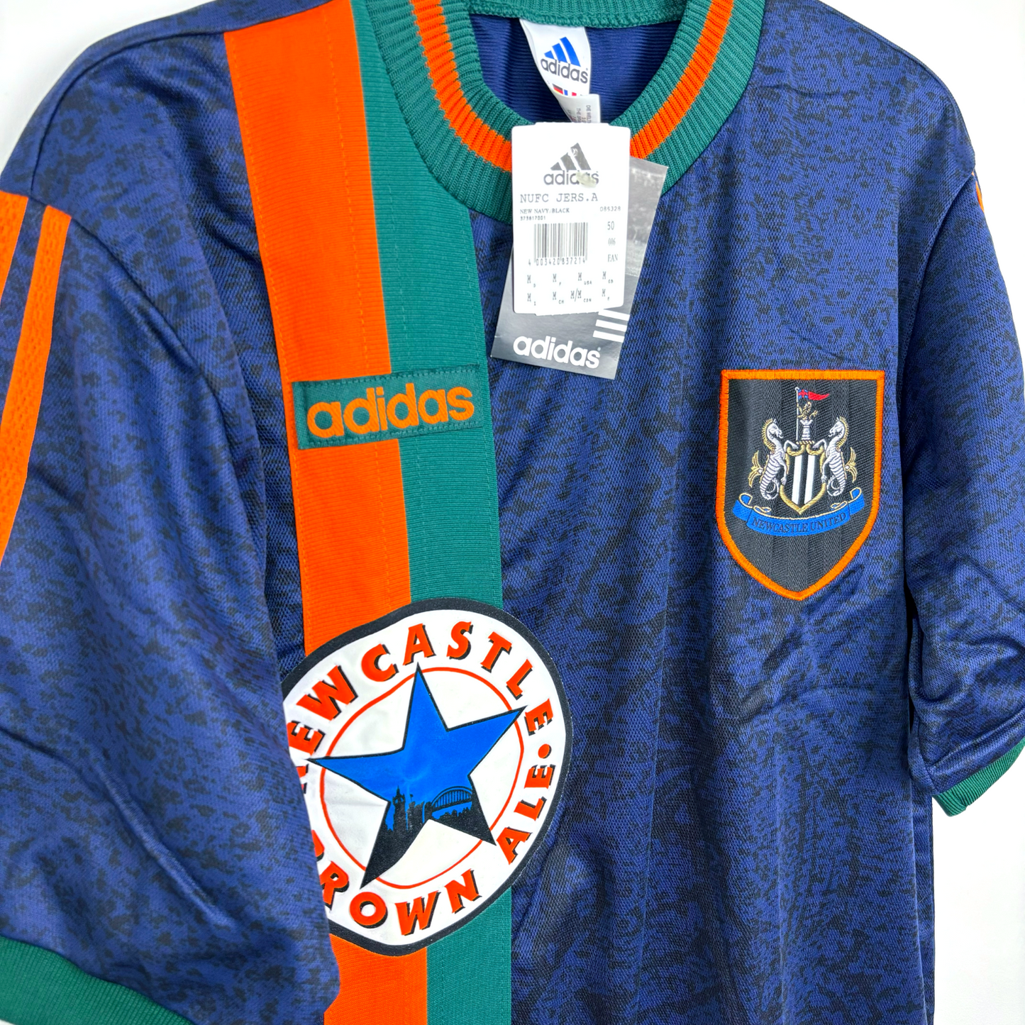 Newcaslte United classic football shirt produced by Adidas. Navy body featuring duel green and orange stripes and crew neck collar.