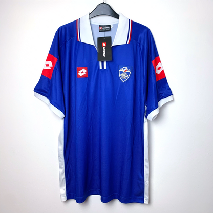 Blue 2002 Yugoslavia shirt by Lotto with red and white accents on a hanger against a white background