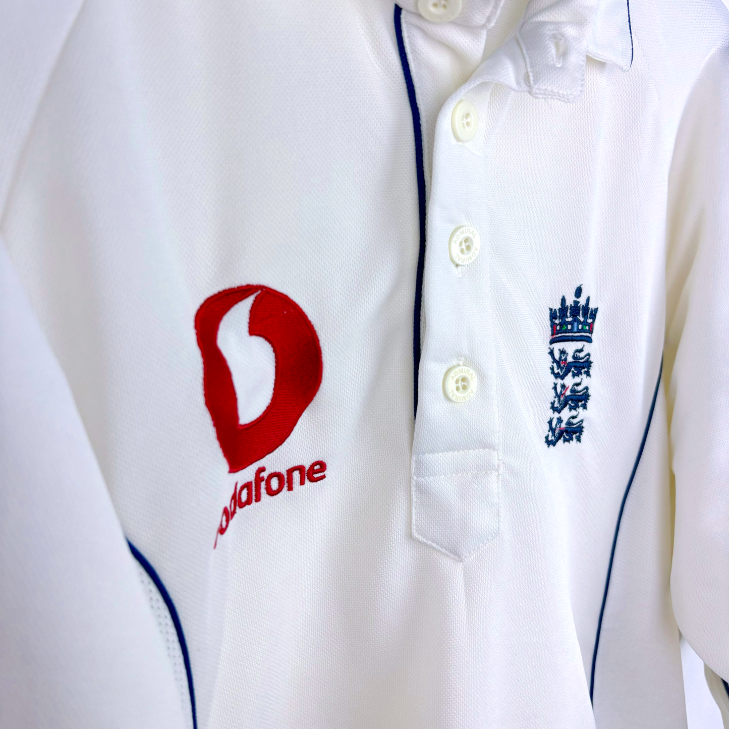 White England cricket shirt with blue piping, Vodafone logo, and embroidered Three Lions crest, vintage football shirt style. - England 2005/2006/2007/2008 Ashes Cricket Shirt
