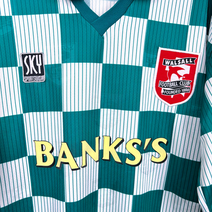 Close up of Walsall retro soccer jersey produced by Sky Leisure. Check green and off-white pattern with Banks's yellow sponsor. Embroidered club crest.