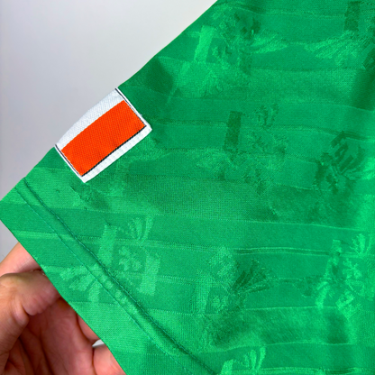 Green vintage football shirt sleeve with orange, white, and green Ireland flag patch, retro football shirts texture. - Eire Ireland 1994-1995 USA World Cup Home Football Shirt Adidas
