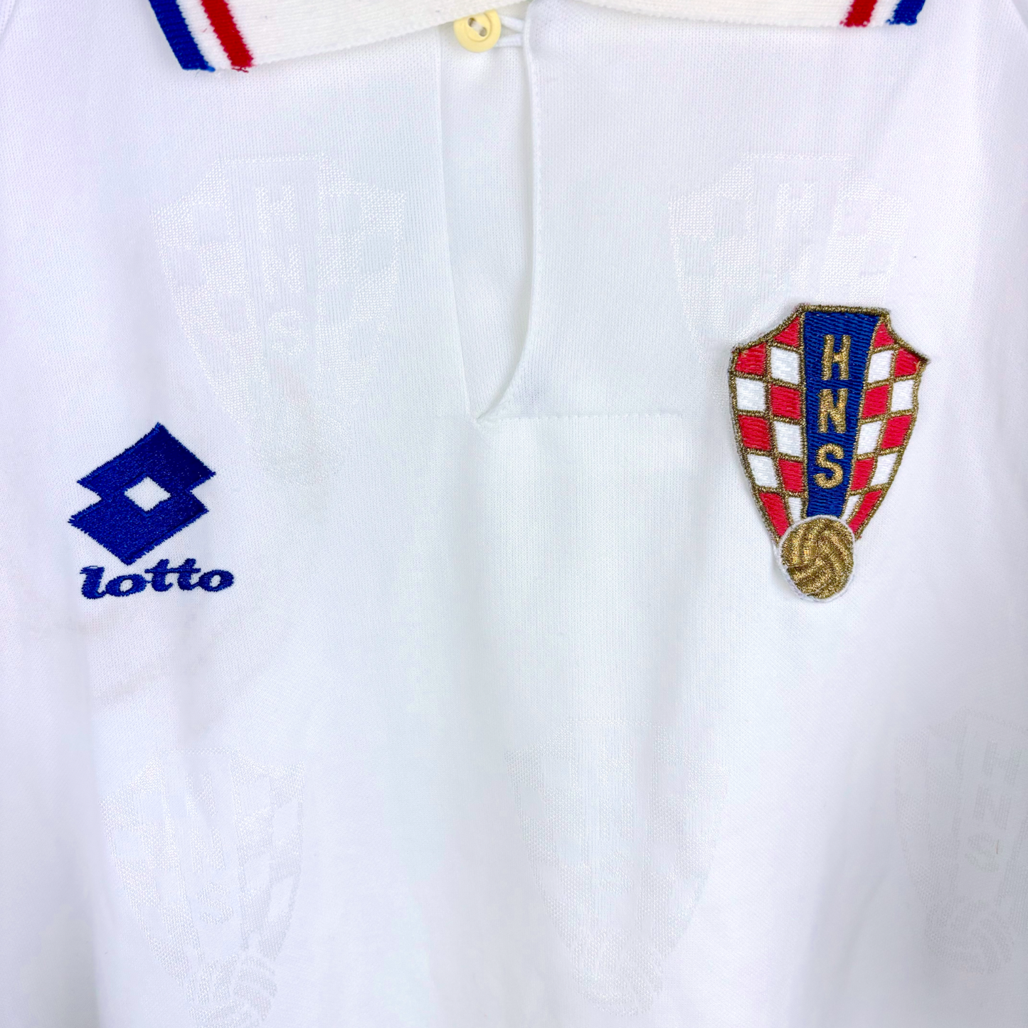 White vintage football shirt with subtle checkered pattern, Croatia HNS crest, blue Lotto logo, and collar with red and blue - Croatia 1996/1997/1998 Lotto Away Football Shirt