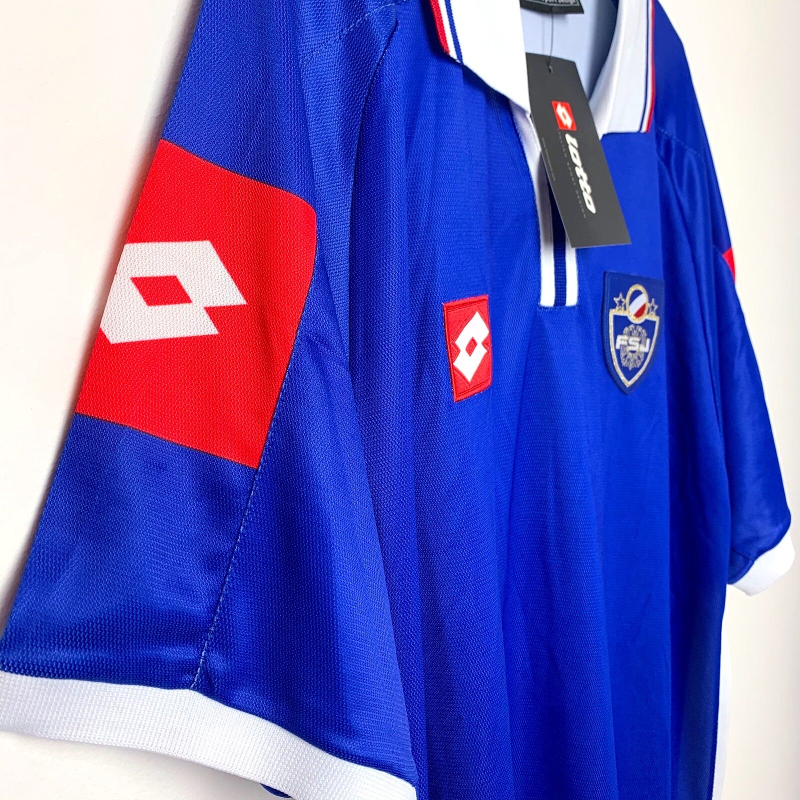 Side view of blue 2002 Yugoslavia shirt by Lotto with red and white accents 