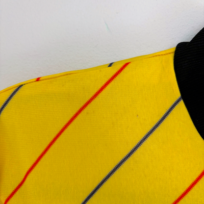 Yellow vintage football shirt with thin red and blue diagonal stripes and a black collar, classic retro soccer jersey style. - Millwall 1987/1988/1989 Away Football Shirt Spall