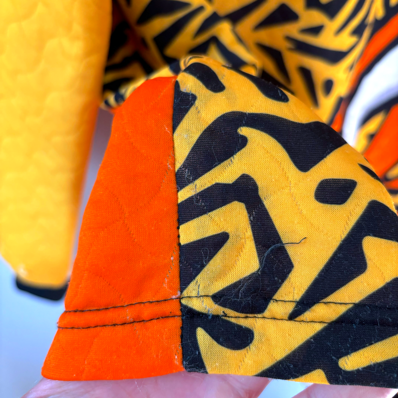 Liverpool FC 1995-1996 vintage football shirt sleeve detail with yellow quilted fabric and black geometric pattern on orange . - Liverpool FC 1995-1996 Goal Keeper Football Shirt Adidas