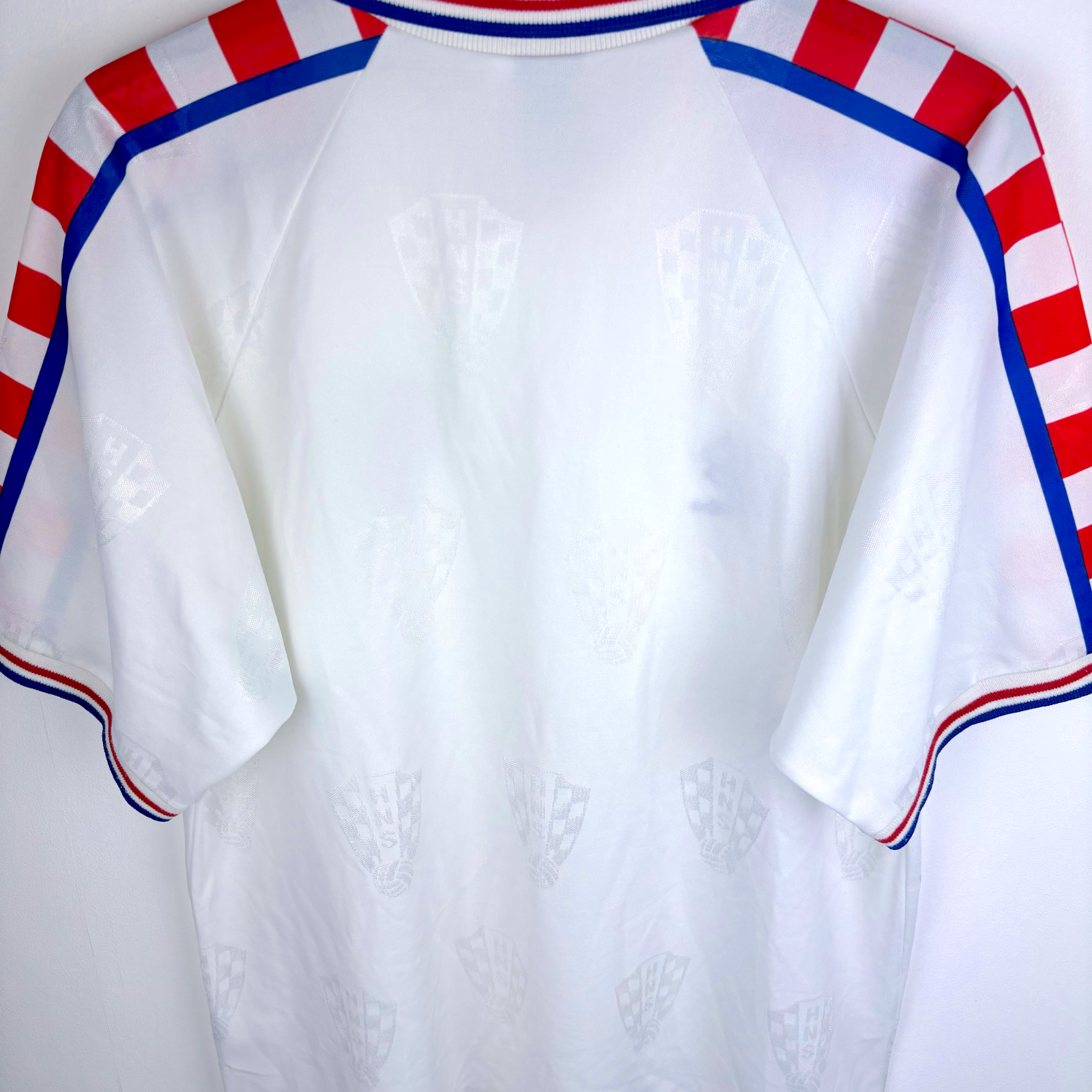 White vintage Croatia football shirt with subtle checkered pattern, red and blue striped shoulder accents, and blue trim on. - Croatia 1996/1997/1998 Lotto Away Football Shirt