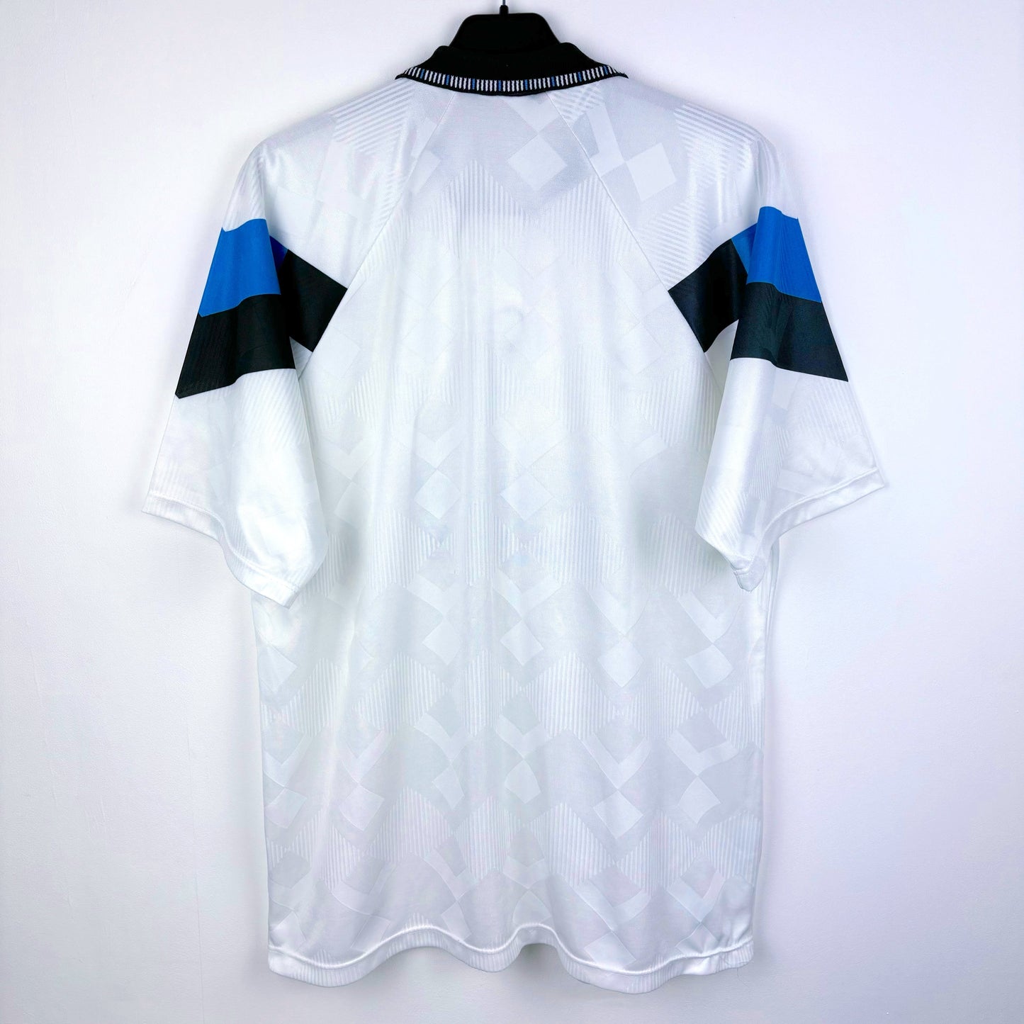 Rear view of Aston Villa 1990-1993 away classic football shirt made by Umbro. Sublimated jacquard pattern ion white body. Black and blue trim with black Mita Copiers sponsor.
