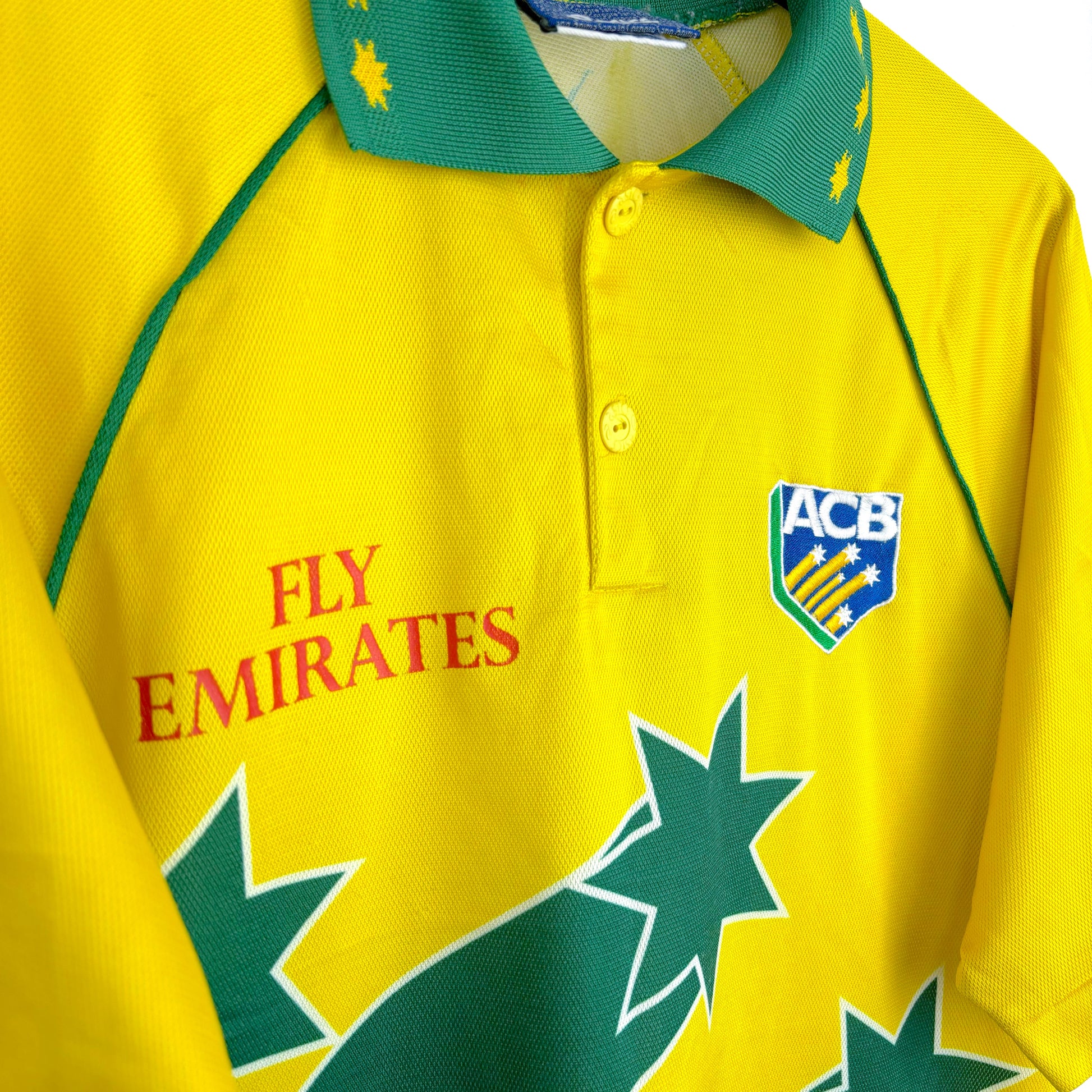 Classic Australia 1999 World Cup cricket shirt by Asics, close-up side view of Fly Emirates sponsor logo and yellow and green fabric details