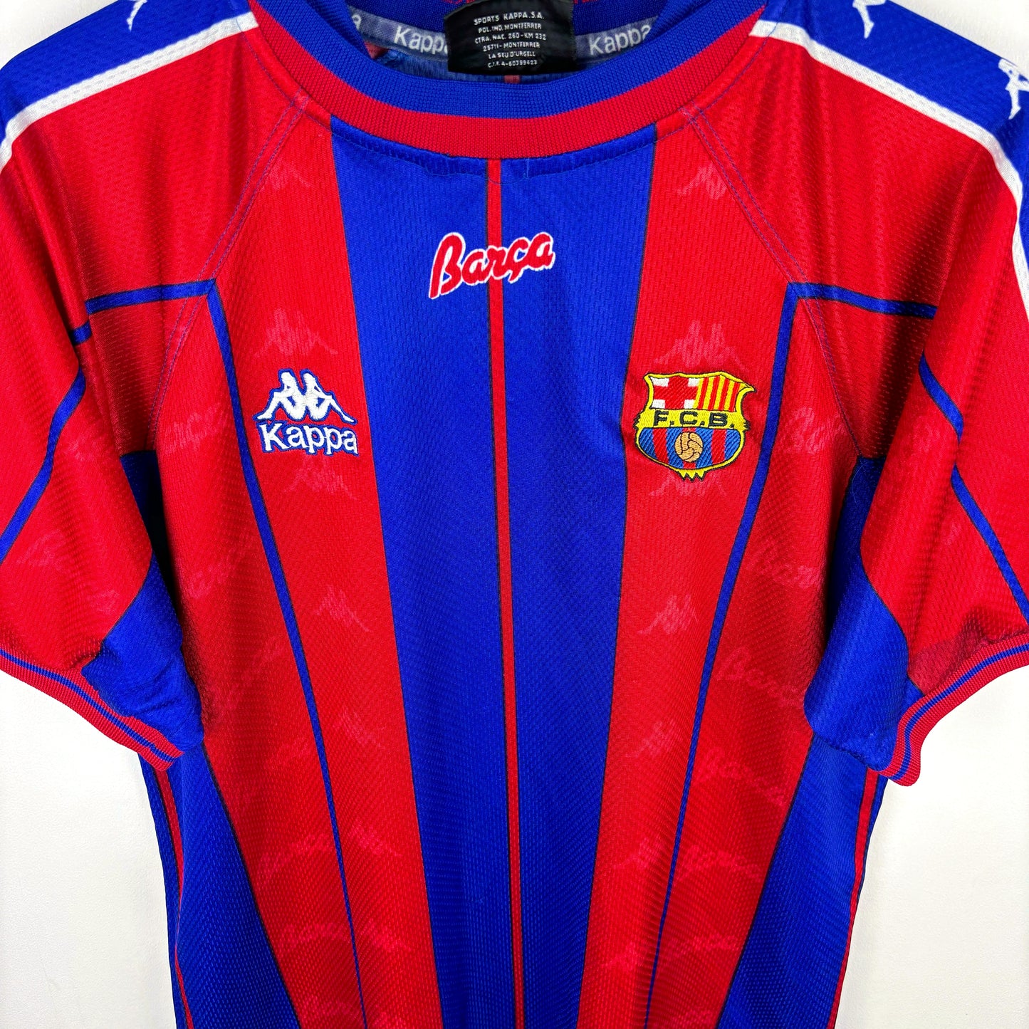 Angled view of FC Barcelona 1997-1998 home retro soccer jersey made by Kappa. Red and blue stripes with embroidered badge.