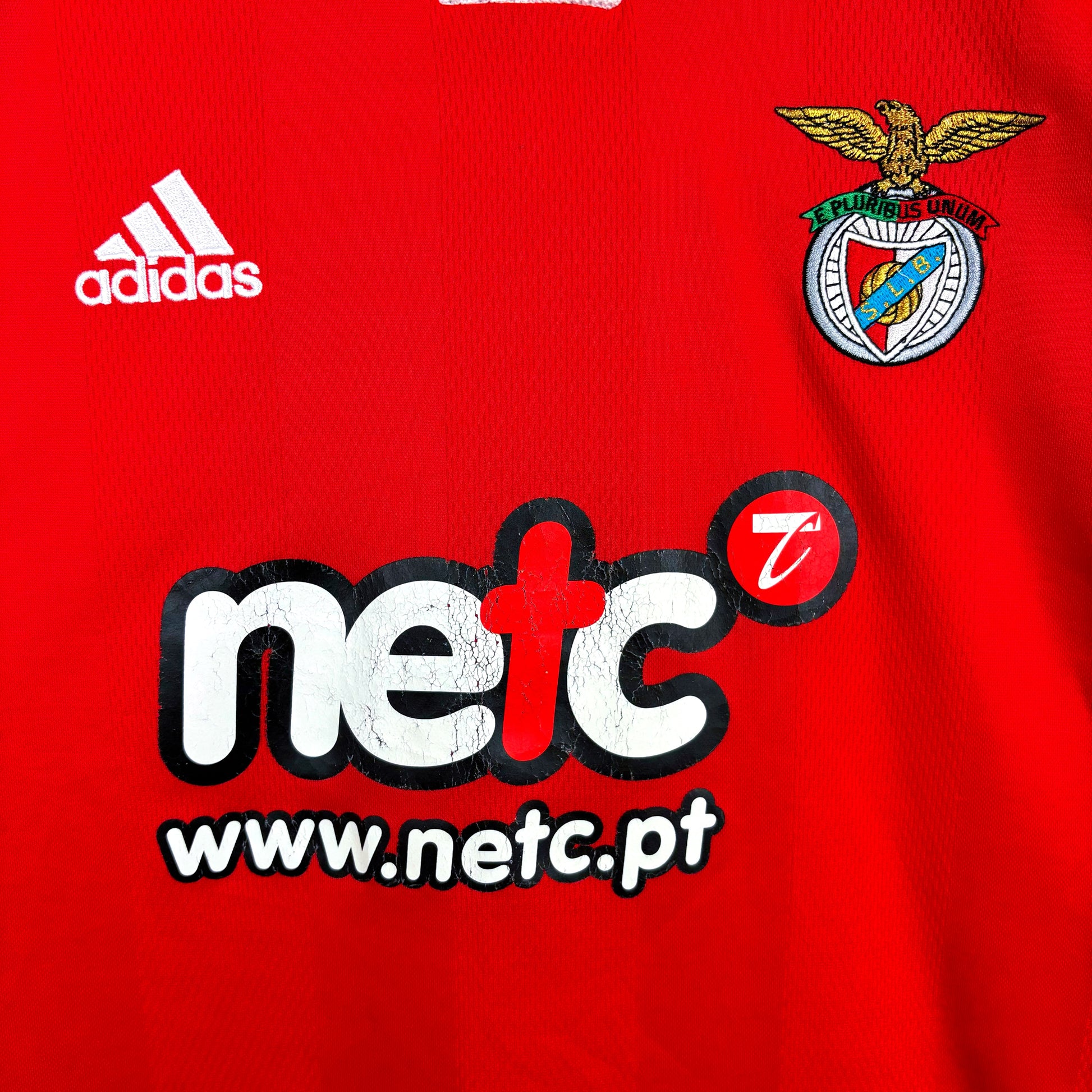 Close up of badges and sponsor on Benfica 2000-2001 Adidas home classic football shirt. Red body with white trim. NETC sponsor.