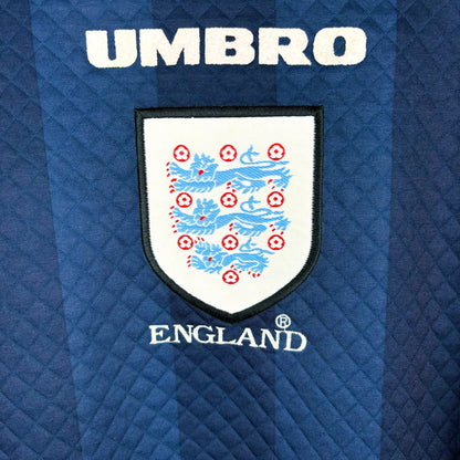 Close up of badge on England 1997-1998 goalkeeper vintage soccer jersey made by Umbro. Embroidered England badge and text.