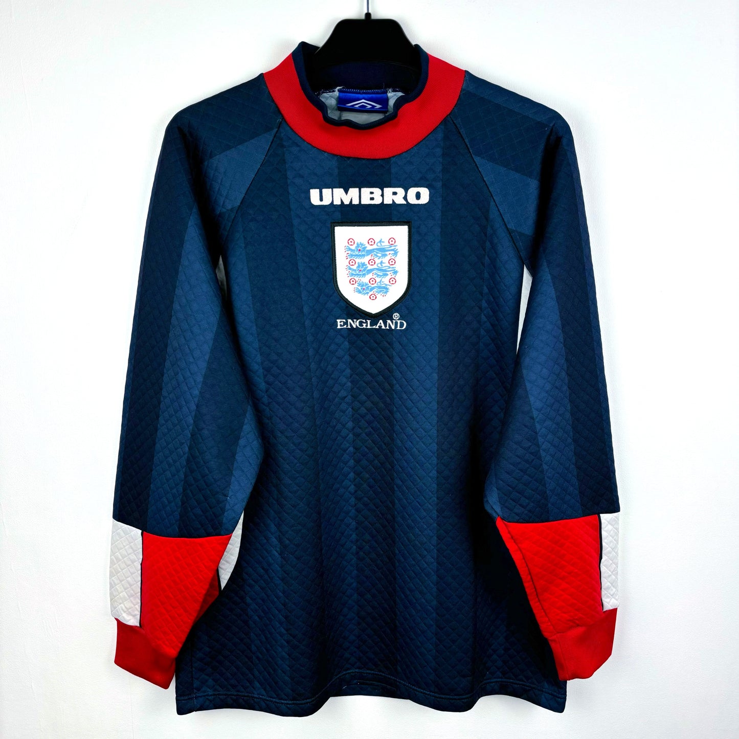 England 1997-1998 goalkeeper classic football shirt made by Umbro. Dual navy body with red collar and tipped sleeves. Worn during 1998 World Cup.
