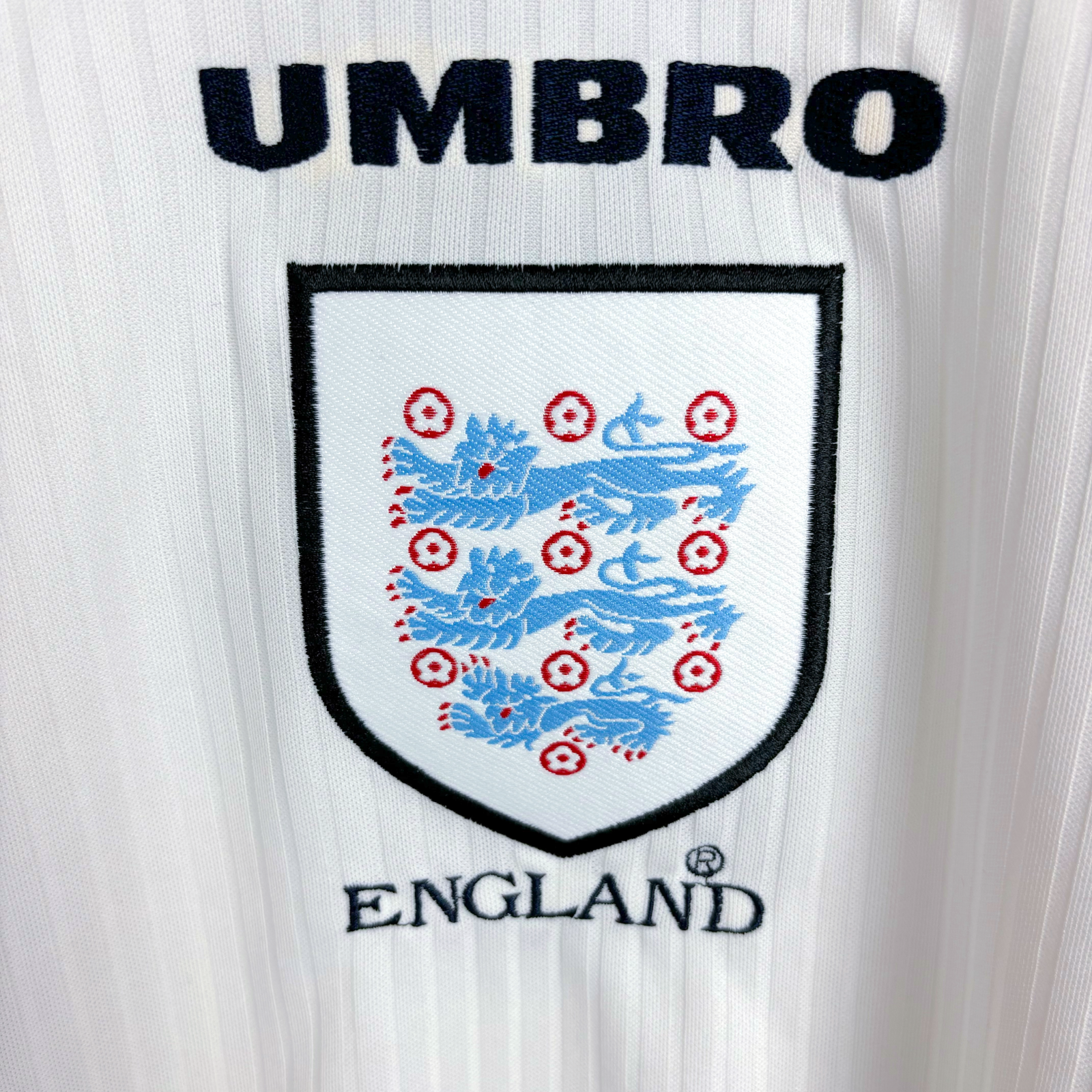 Close up of badge on classic England 1998-1999 home football shirt by Umbro.