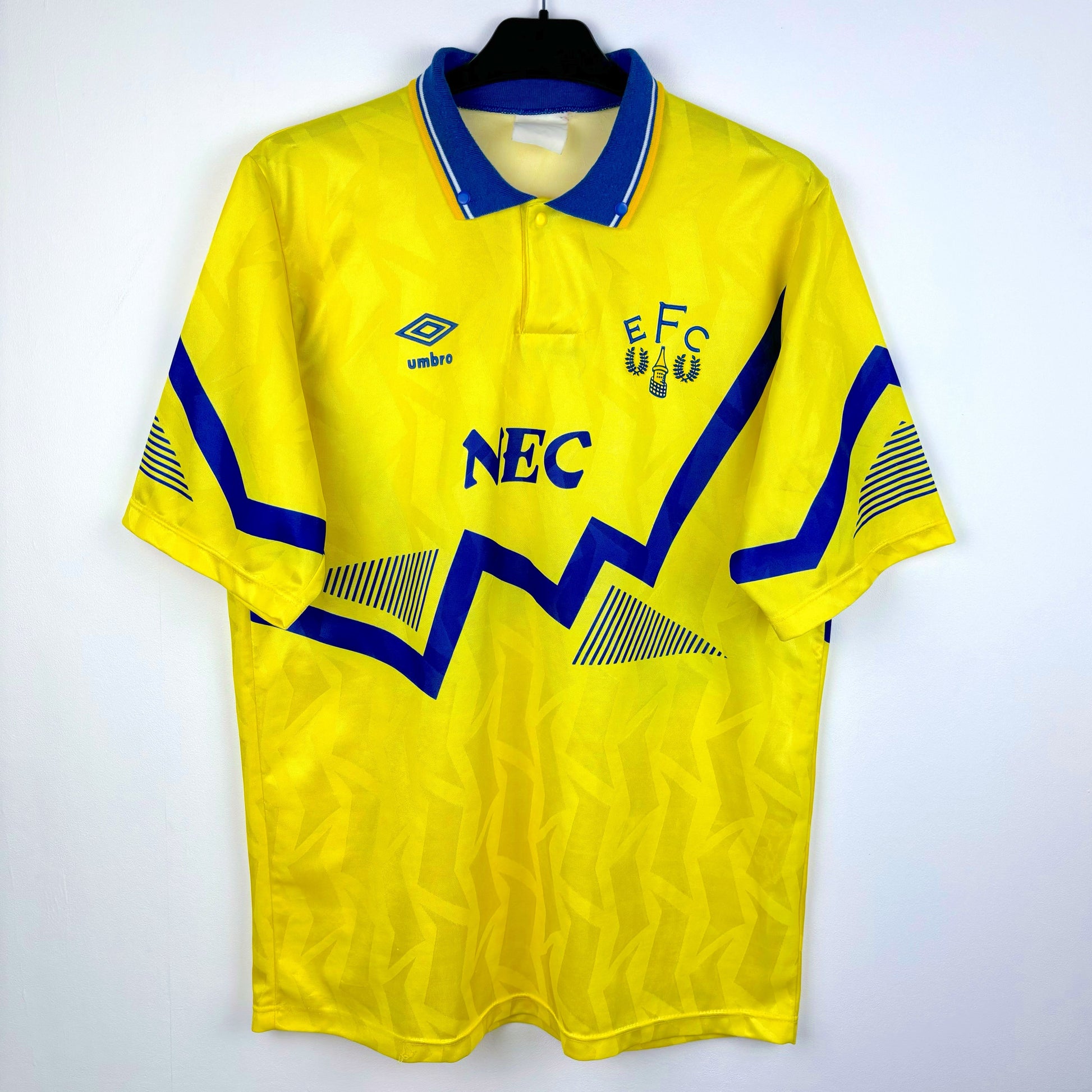 Everton 1990-1992 away retro football shirt made by Umbro. Blue sublimated zig-zag across yellow body . NEC sponsor.