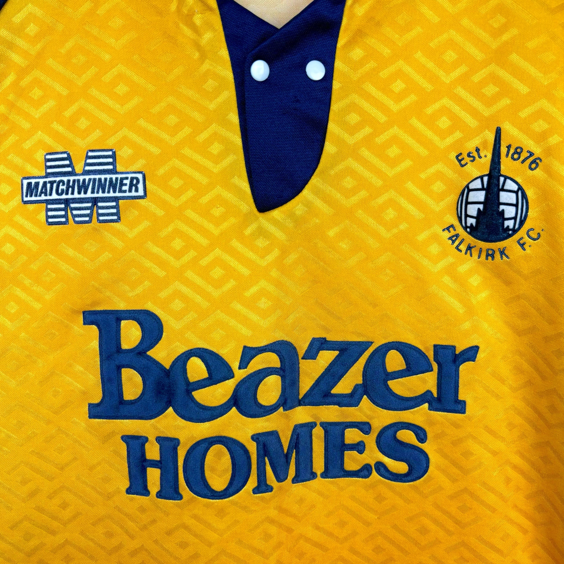 Close up of badges on Falkirk 1994-1995 Matchwinner away retro football shirt.