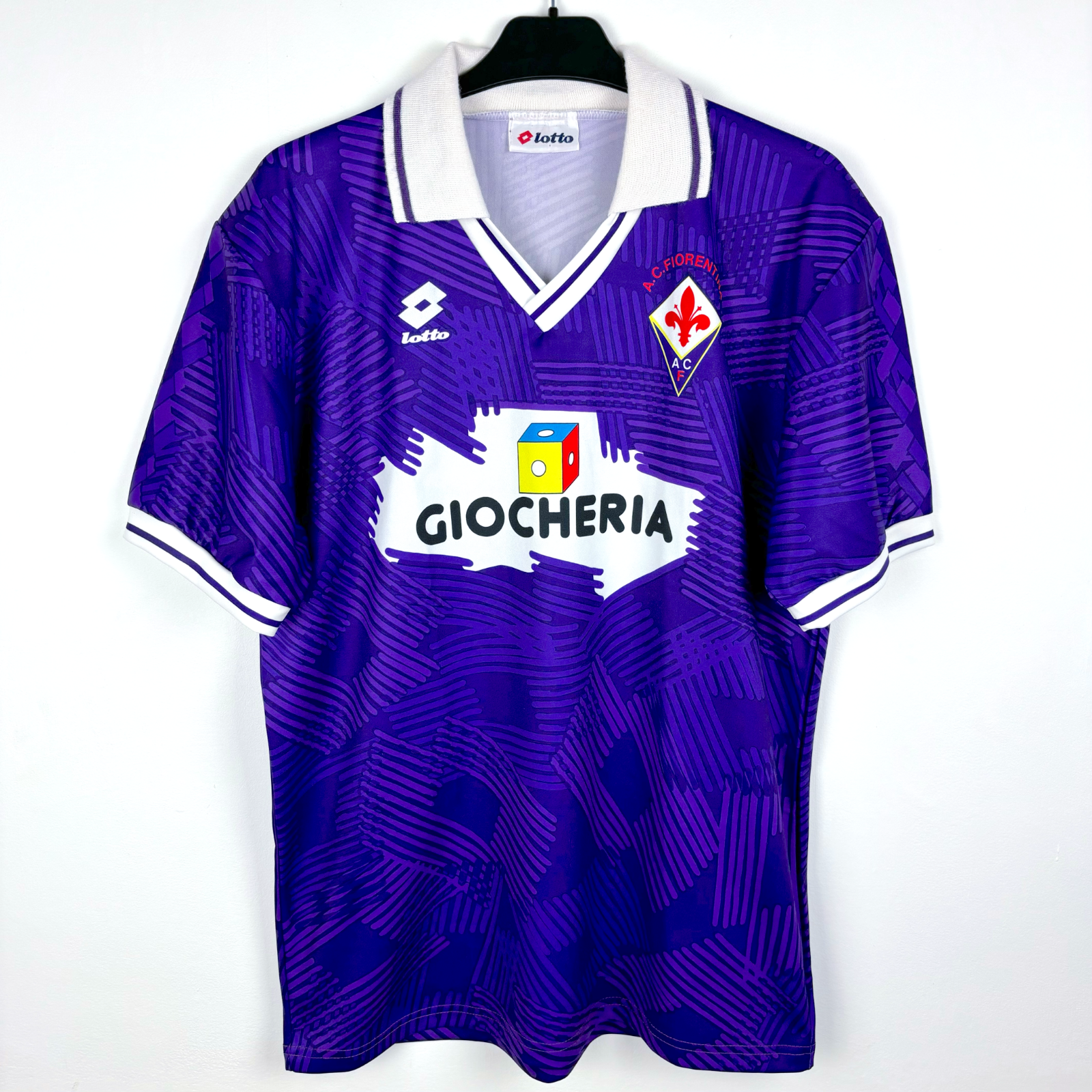 Fiorentina 1991-1992 classic home football shirt produced by Lotto. Purple body spanned by Lotto logo pattern and white collar.