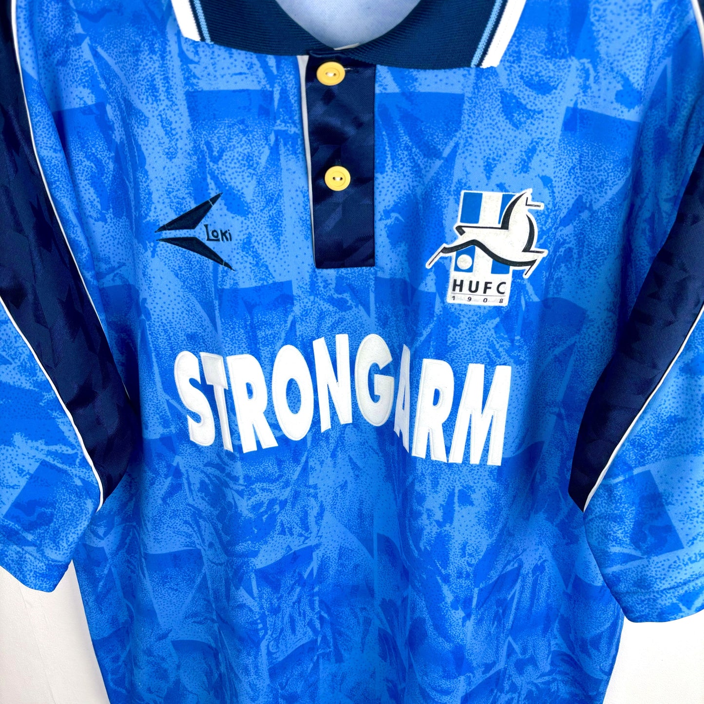 Downward view of Hartlepool United 1993-1995 home classic football shirt with 'Strongarm' sponsor. Blue body with navy trim and collar.