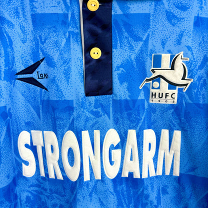 Close up view of Hartlepool United 1993-1995 retro football shirt with 'Strongarm' sponsor and hart club badge. Blue body with navy trim and collar. 