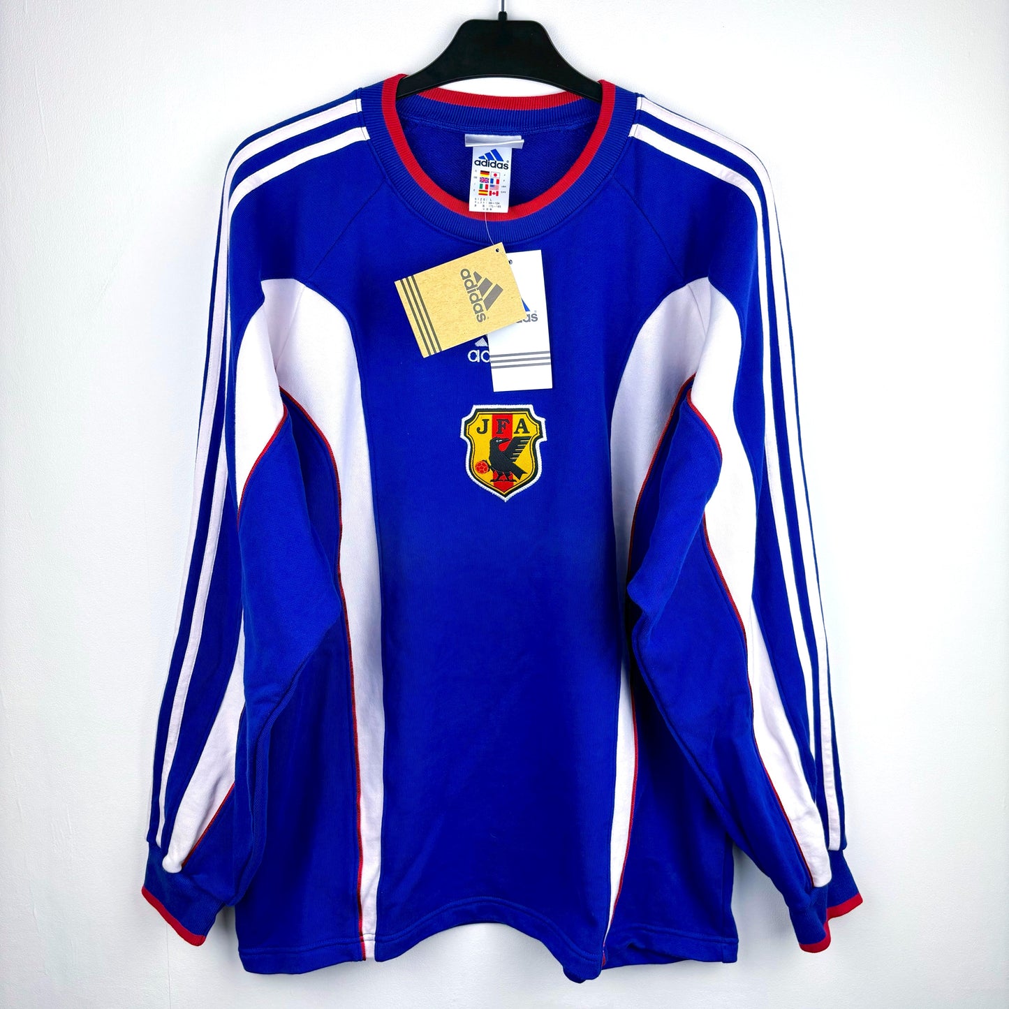 Japan 1999-2000 adidas vintage football sweatshirt. Blue body with white vertical swooshes and red trim. Brand new with tags attached. 