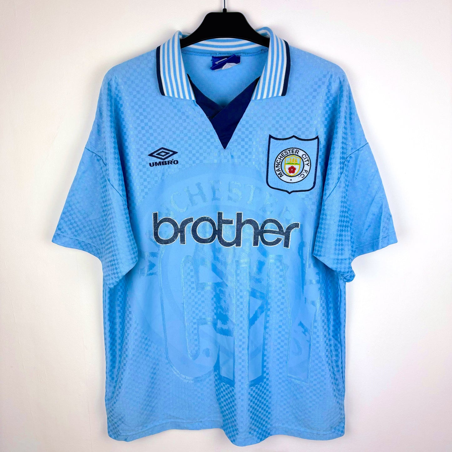 Man City 1995-1997 Umbro home vintage football shirt. Sky blue body with sublimated checkered pattern. Brother sponsor.