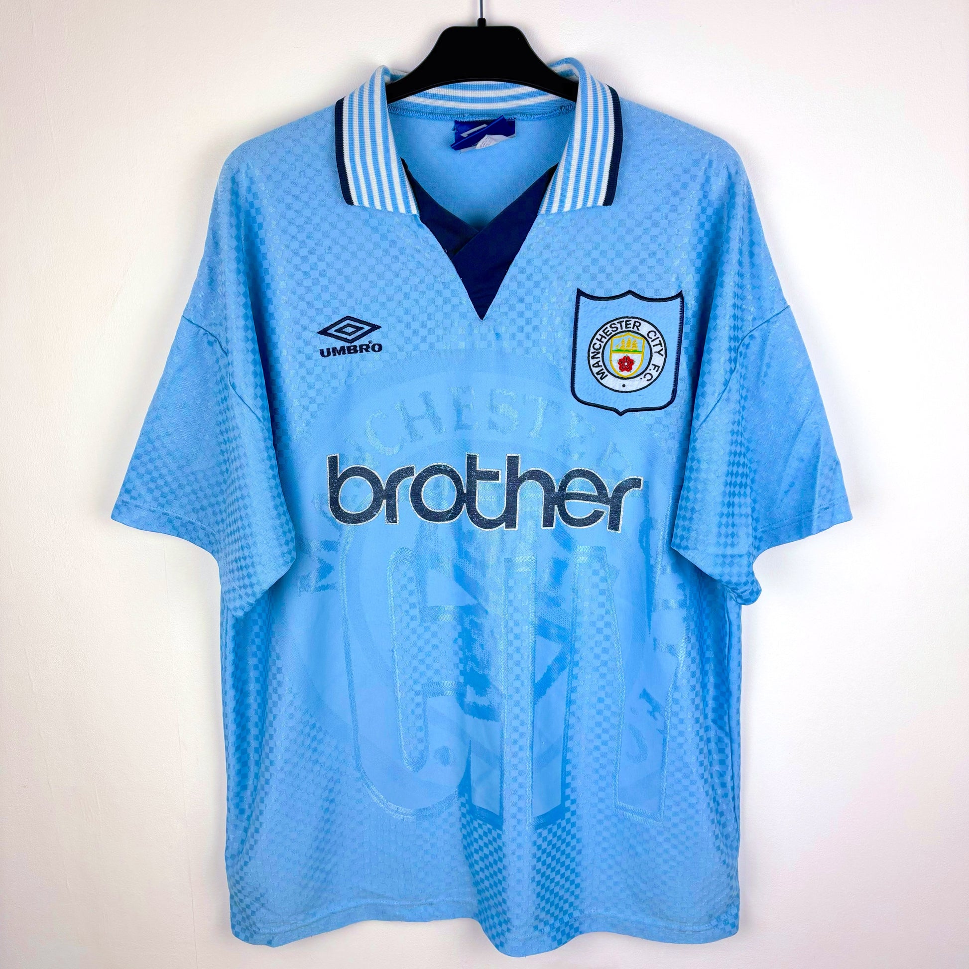 Man City 1995-1997 Umbro home vintage football shirt. Sky blue body with sublimated checkered pattern. Brother sponsor.