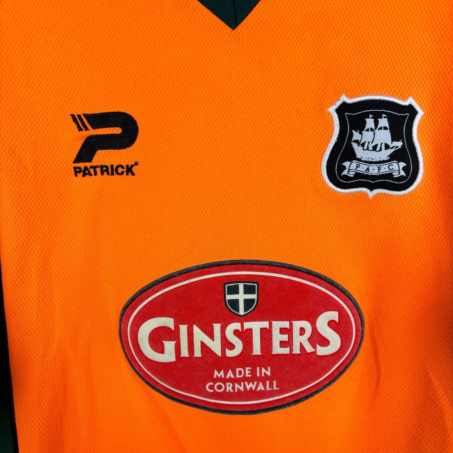 Close up of badges and Ginsters sponsor on Plymouth Argyle 2002-2003 Patrick away classic football shirt.