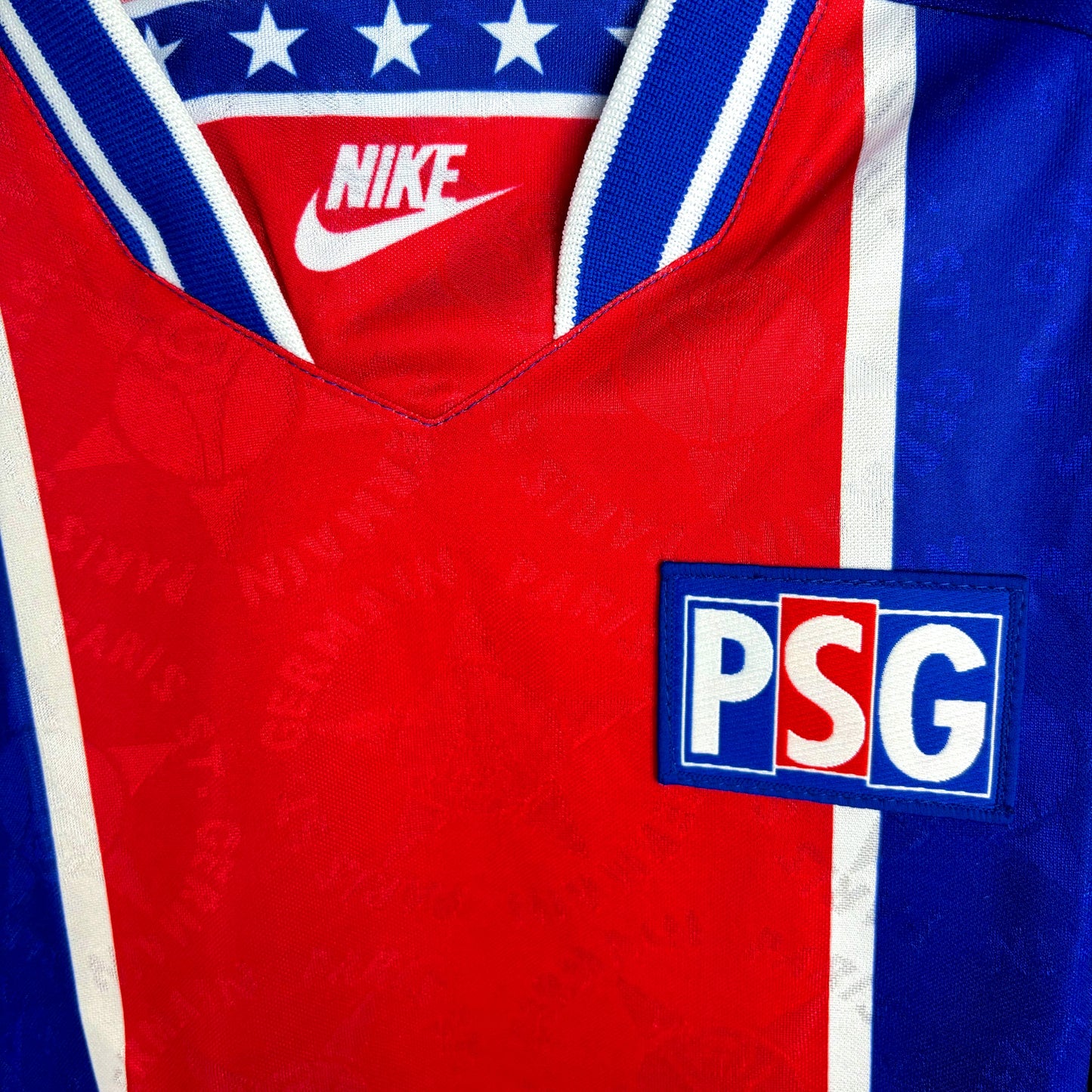 Close up of club badge on PSG 1994-1995 Nike home classic football shirt. Long-sleeved blue body with central red vertical stripe and white trim.