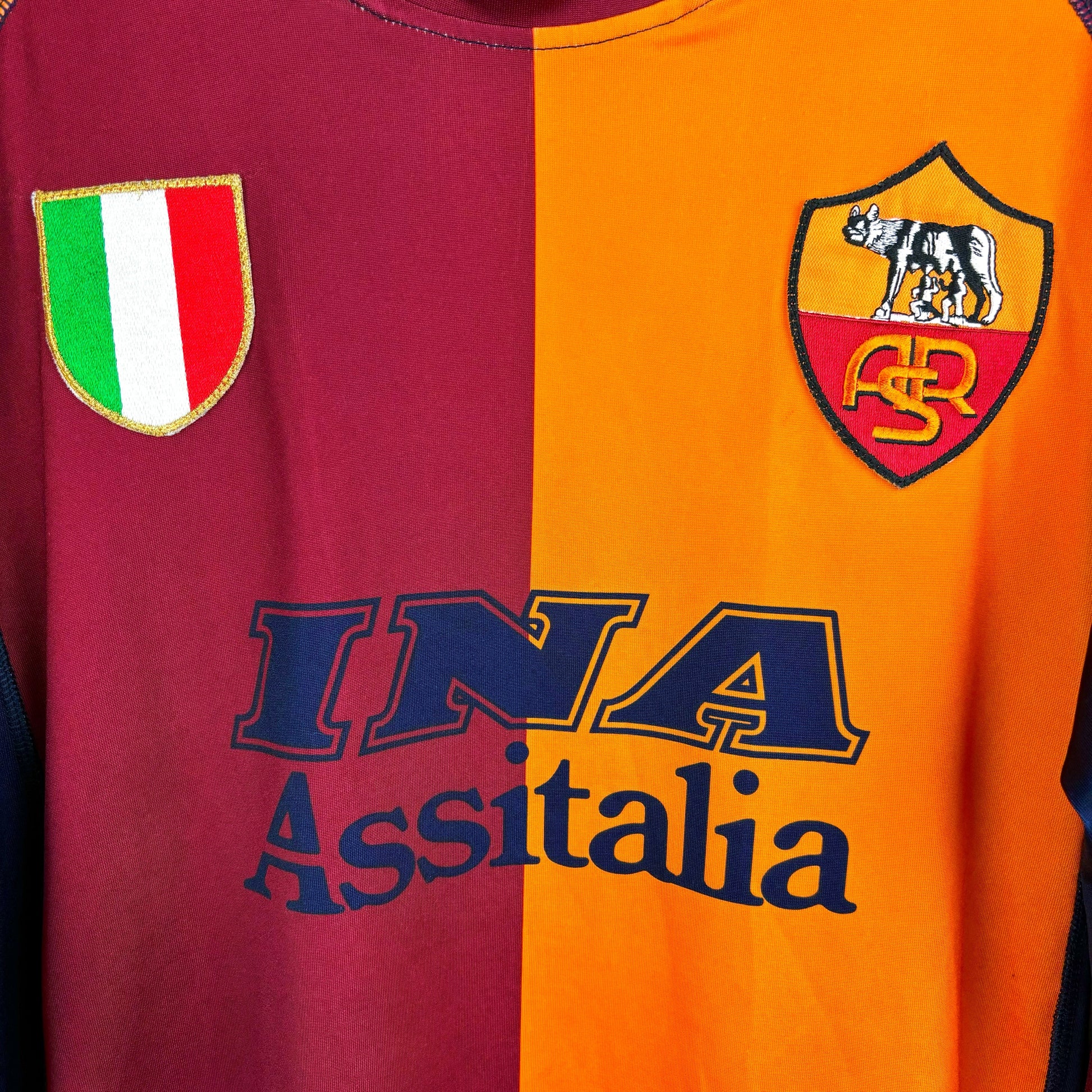 Roma 2001-2002 Kappa vintage football shirt in orange and maroon with navy trim. Close up of INA Assitalia sponsor and embroidered Scudetto and club badge.